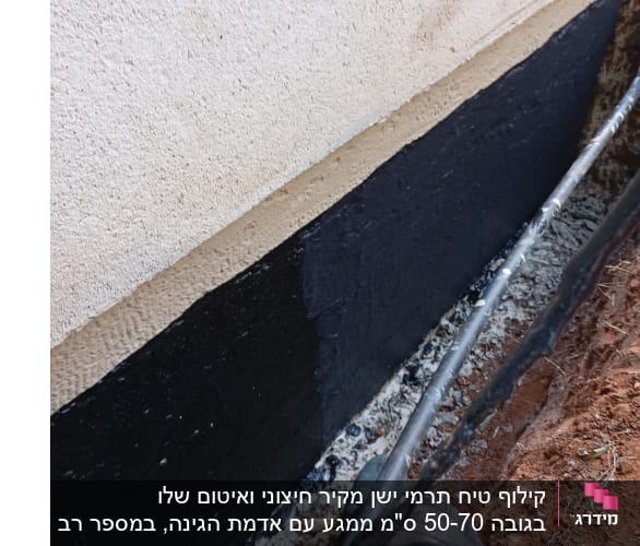 עבודת איטום על קיר חיצוני עם חומר שחור